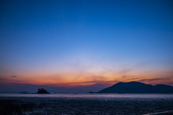 夜晚蓝色海面晚霞摄影图