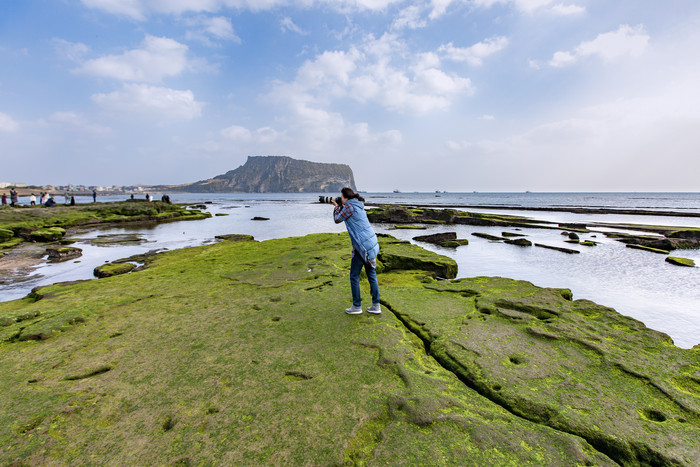 海岸边青苔女子摄影图