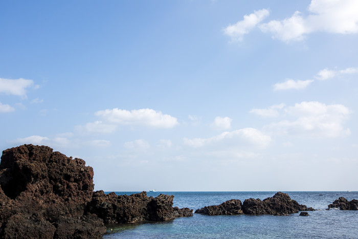海岸边海水礁石摄影图