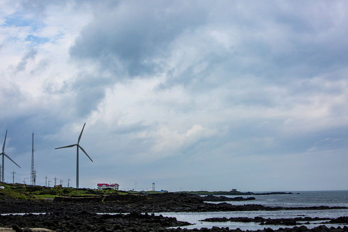 美丽海边风力发电房子摄影图