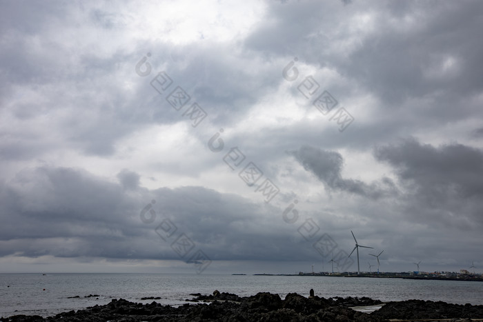 阴暗海上天气风力发电机摄影图