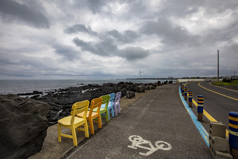 海岸边公路文艺多彩椅子摄影图