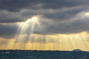 海边梦幻光线穿越云层摄影图