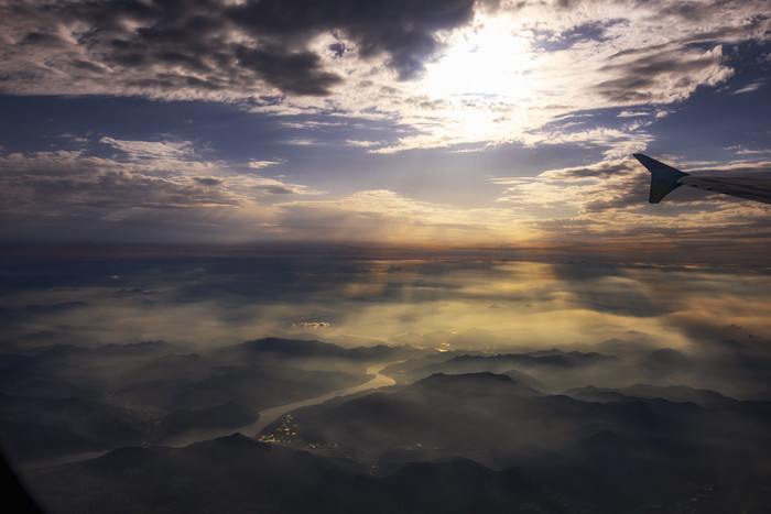 空中拍摄耀眼太阳山川大地摄影图