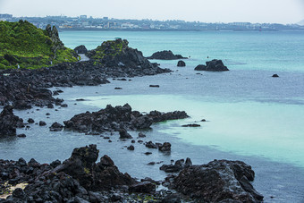 海岸边浪拍礁石碎石摄影图
