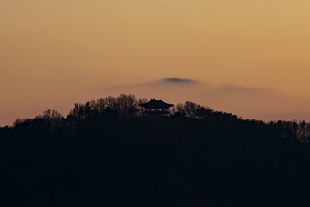 落日余晖山顶亭子摄影图
