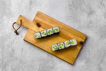 案板上的绿色寿司摄影图
