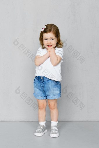 站在墙面前拍照的可爱小女孩