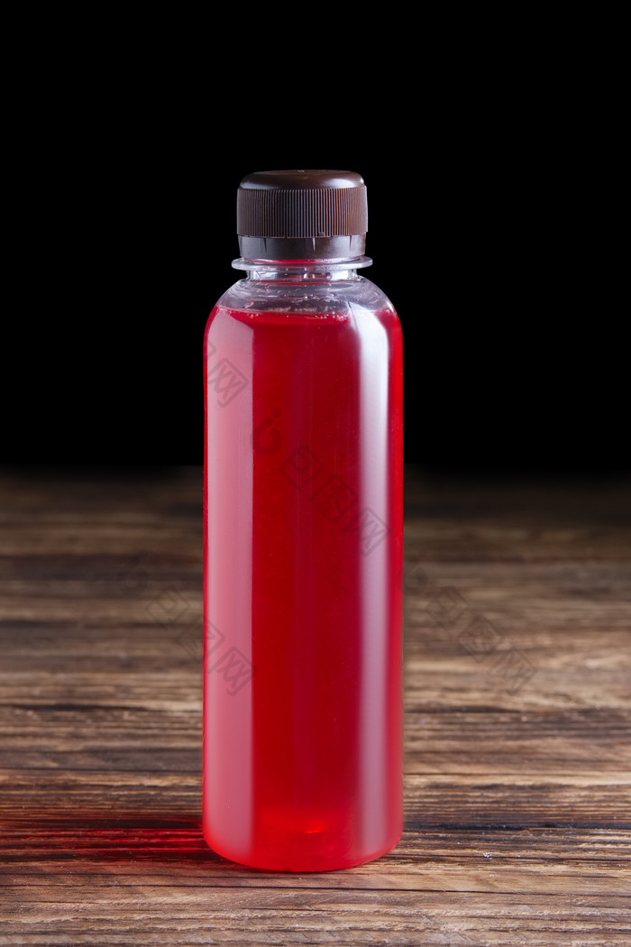 玻璃瓶红色饮料摄影图