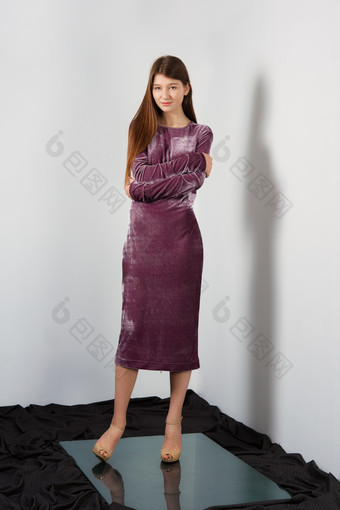女人穿紫色天鹅绒紧身裙抱臂