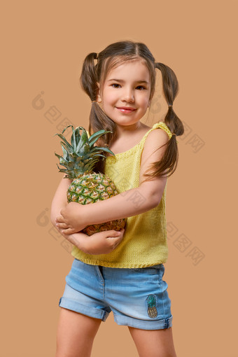扎着长尾辫抱着菠萝的小女孩
