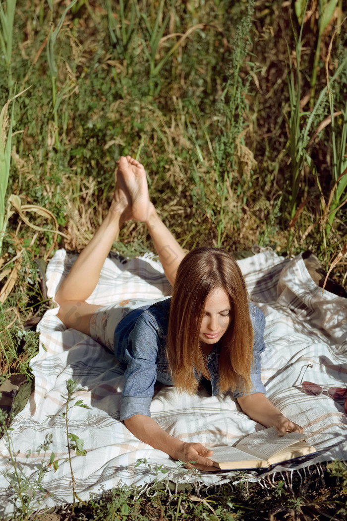趴在草地上看书的女人
