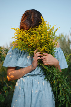 抱着一束鲜花在阳光下拍摄的少女