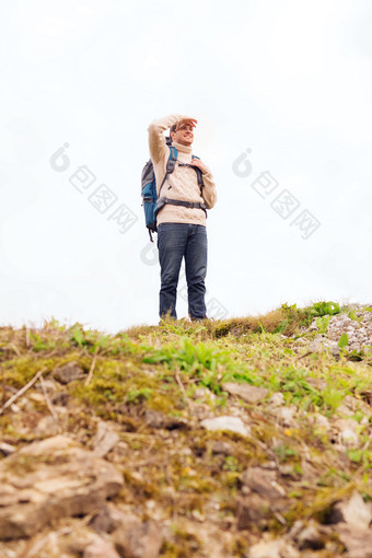 背着登山包远眺的男子