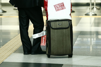 站在机场大厅提着行李的人