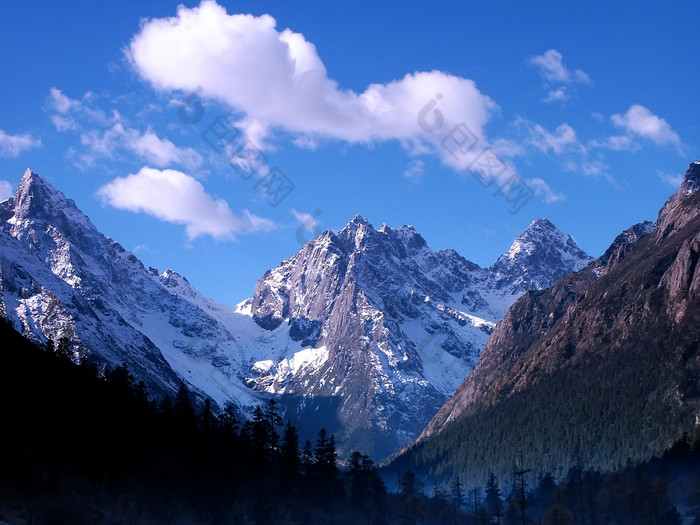 蓝天白云下的山峰雪山