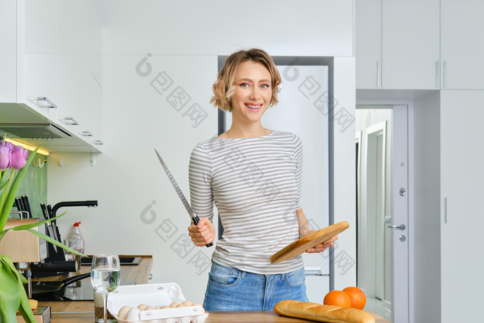 手持餐刀做饭的家庭主妇