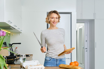 手持餐刀做饭的家庭主妇