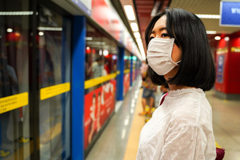 女人戴着口罩等待地铁