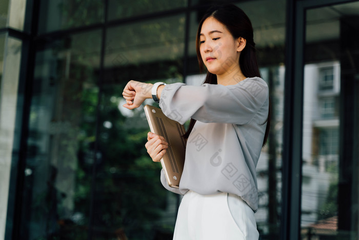 女人手拿电脑看时间