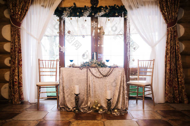 漂亮的餐桌,金盘装饰着云杉和酒杯.圣诞节的概念
