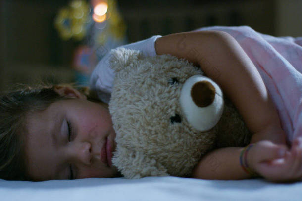 <strong>宝宝</strong>休息静静地躺在床上抱着泰迪熊玩具，和平的梦想和无噪声、 快乐的孩子们和妈妈和爸爸幸福家园的概念。在睡梦中，无咳嗽儿童幸福.