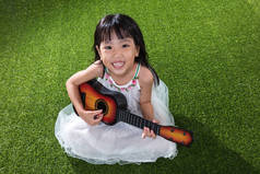 亚洲中国小女孩玩吉他