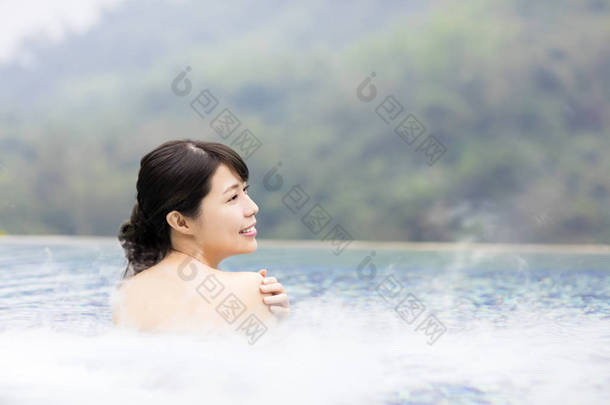 幸福的年轻女人在温泉中休息