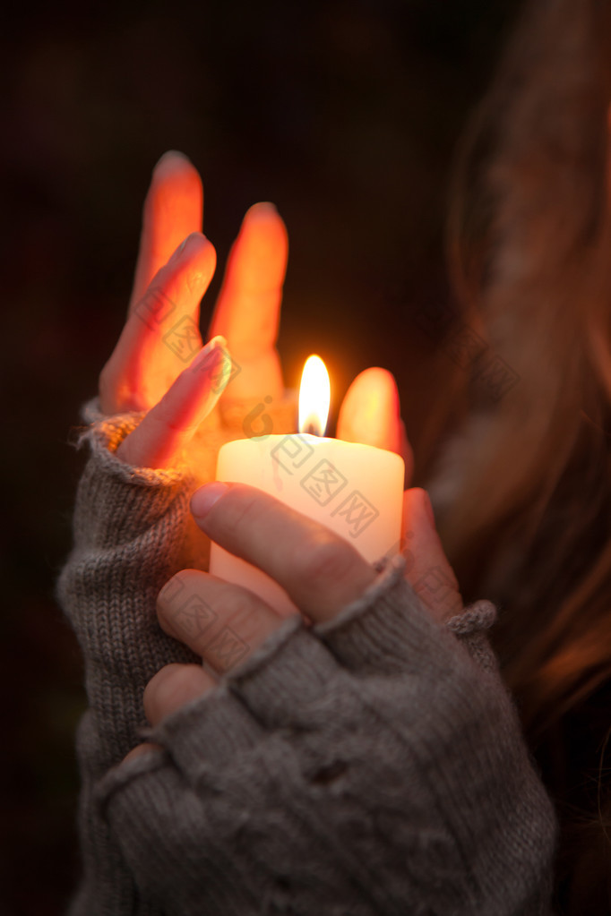 期待着蜡烛祈祷之手带蜡烛在黑暗的背景中的
