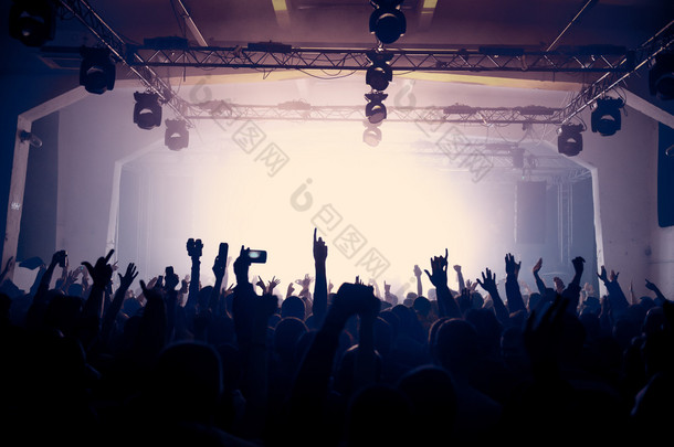 Raised hands on the concert in an old venue