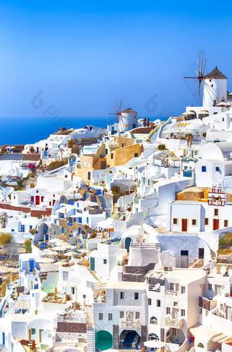 希腊旅行。在希腊的圣托里尼岛上的希腊传统多彩的房子和Oia或Ia的风车。垂直图像取向图片