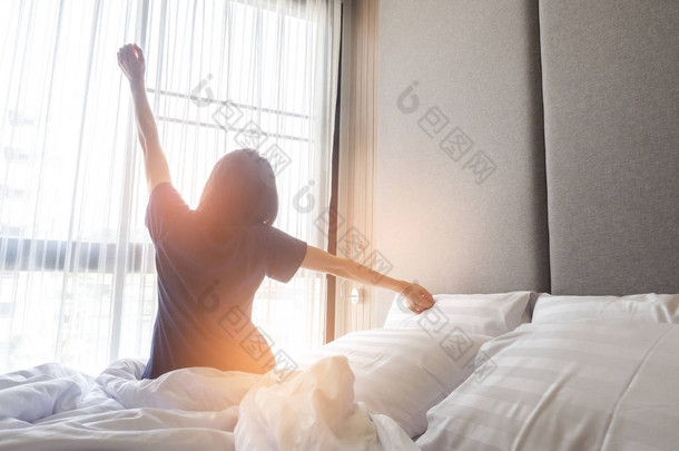 醒来后，后面的观点<strong>伸展</strong>躺在床上的女人
