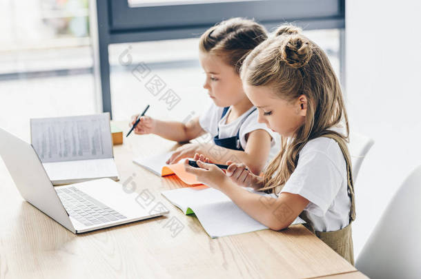 小女生使用膝上型计算机和笔记本电脑进行白色的隔离研究