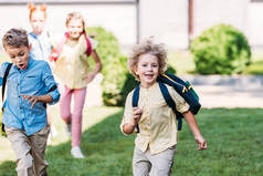 快乐的小学生与同学一起奔跑在学校庭院里