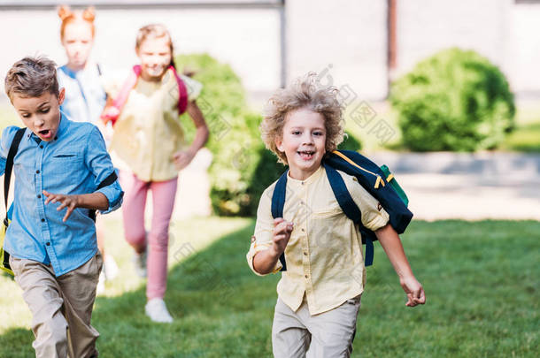快乐的小学生与同学一起奔跑在学校庭院里