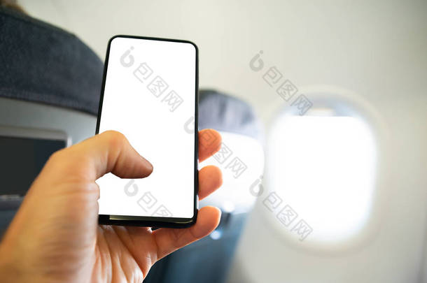 在飞机上用手机与空白屏幕的人的手的特写