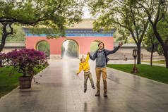 爸爸和儿子是中国大门背景下的游客。中国的儿童旅行理念