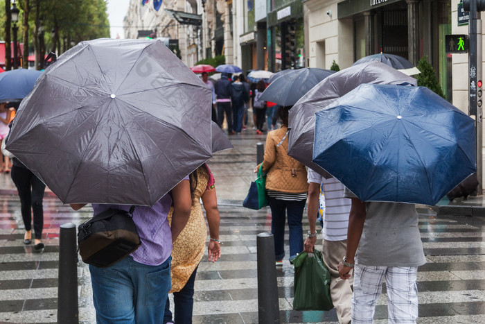 城市马路下雨天雨遮阳伞的人 走路看手机