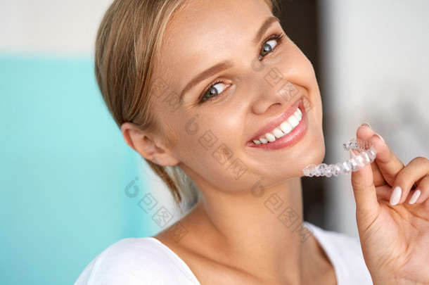 <strong>微笑</strong>的女人与白色牙齿举行牙齿美白托盘