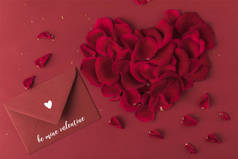 红玫瑰花瓣和信封的心的顶部视图红色, st 情人节概念