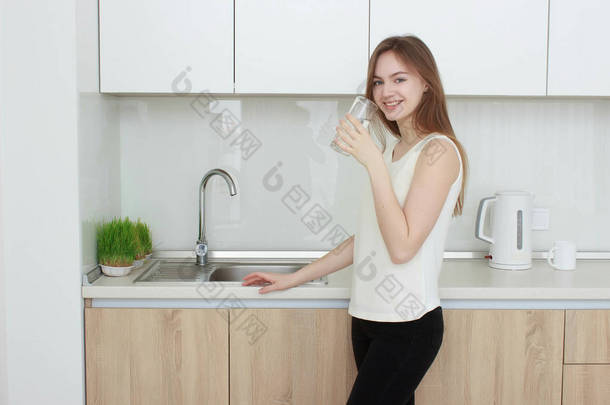 <strong>年轻女子</strong>在厨房喝水