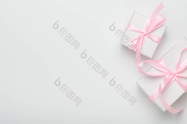 白色背景上有粉色带子<strong>的</strong>礼品盒。概念节日礼物，<strong>恭喜</strong>你。顶视图、复制空间、平面布局.