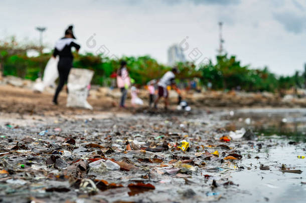 收集<strong>垃圾</strong>的志愿者的模糊。海滩环境污染。志愿者打扫海滩。整理海滩上的<strong>垃圾</strong>。海滩上有油渍。石油泄漏到海洋.