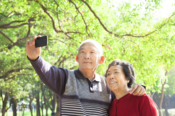 高级夫妇正在拍照<strong>的</strong>自己户外