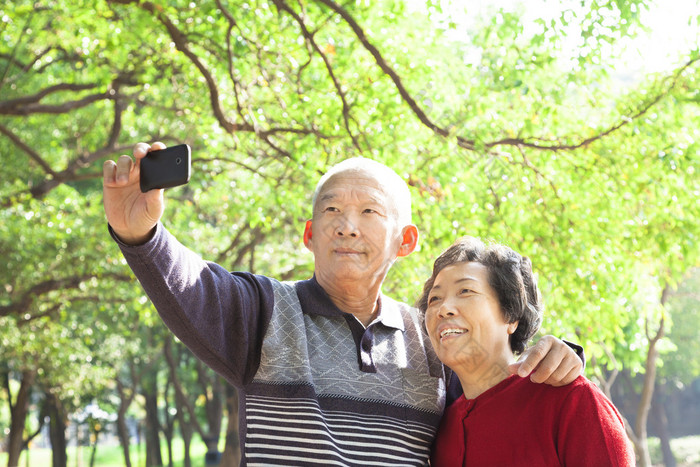 高级夫妇正在拍照的自己户外