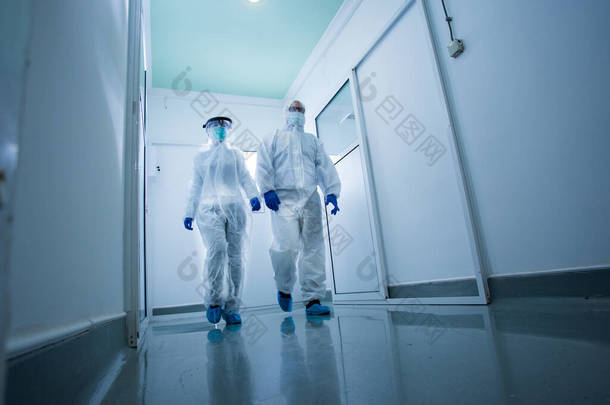 穿着防护<strong>服</strong>的研究人员穿过实验室大厅。病毒和疾病安全概念