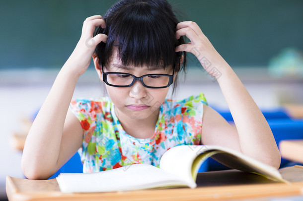 郁闷的小女孩在教室里学习