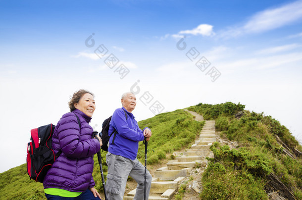 幸福的亚洲高级夫妇在山上徒步旅行