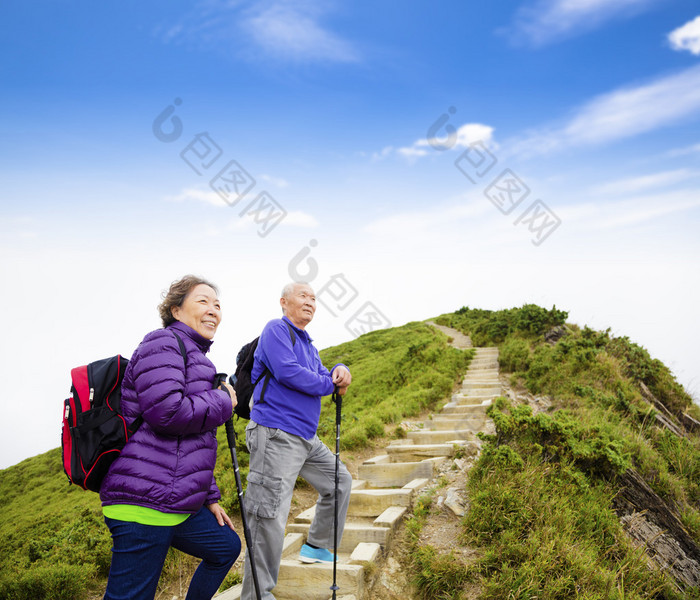 幸福的亚洲高级夫妇在山上徒步旅行