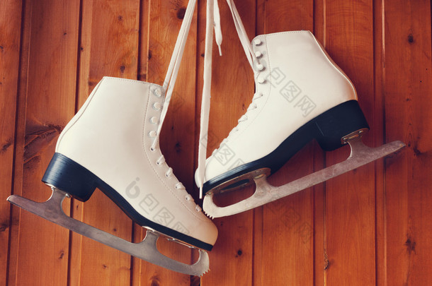 花样滑冰，挂在木制的背景为白色溜冰鞋